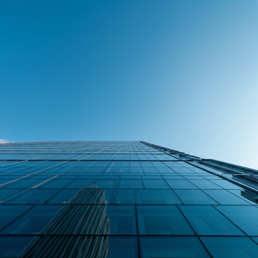 Modern corporate glass building skyscraper looking up at blue sky